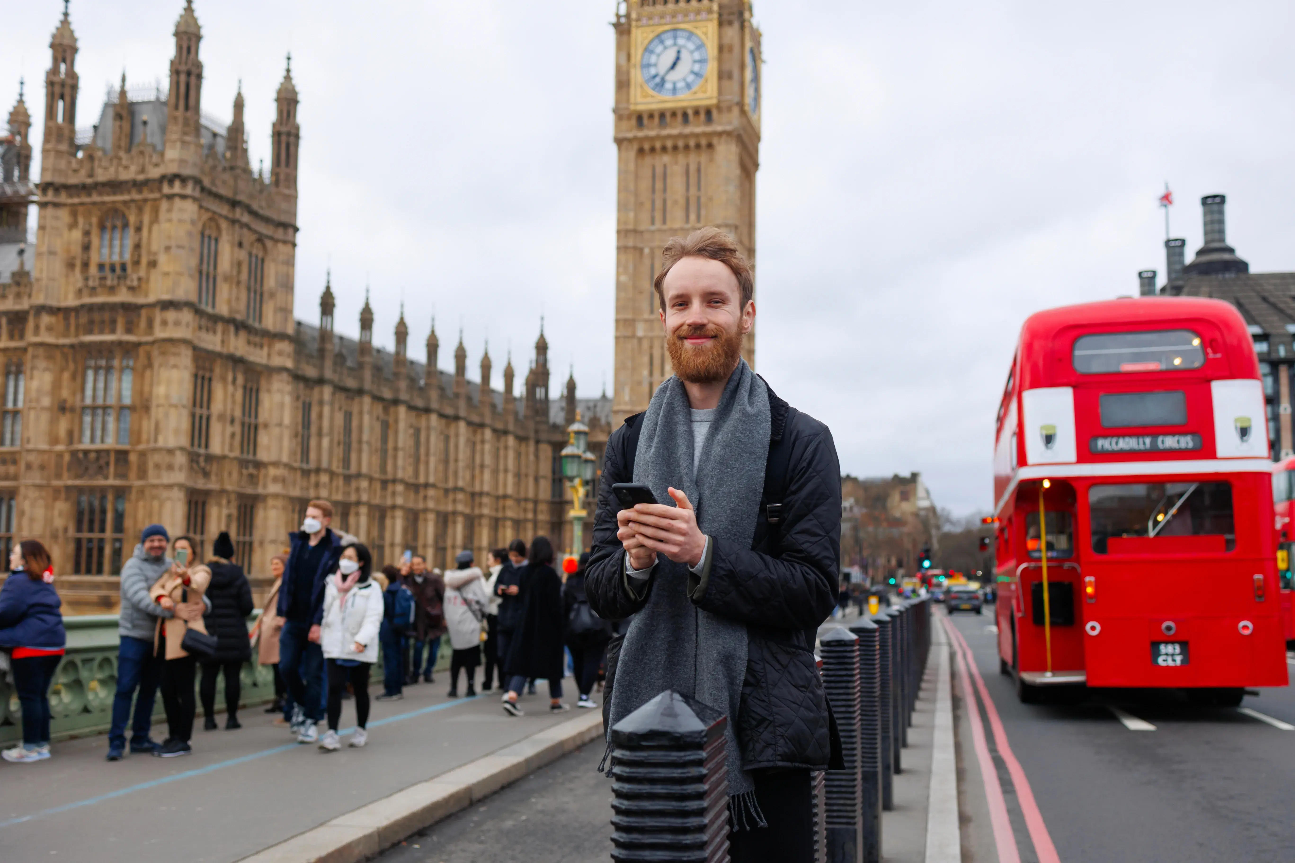 Young man with smartphone on a London street representing British swing voters